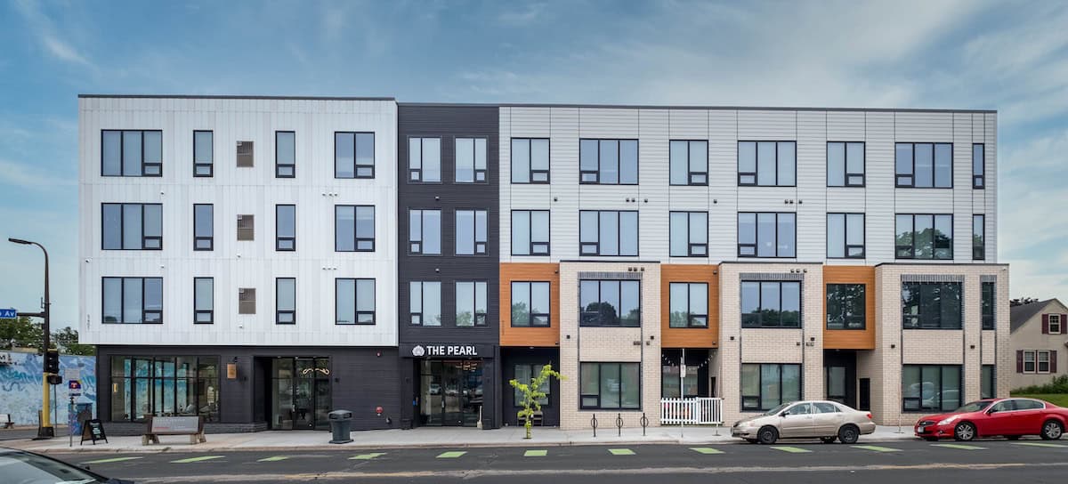 Contemporary multi-story apartment complex in Minneapolis with mixed facade materials and large wind.