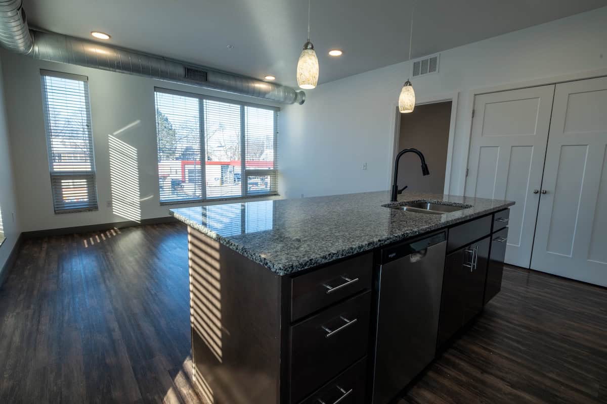 Spacious kitchen featuring granite countertops, modern fixtures, and abundant natural light from lar.