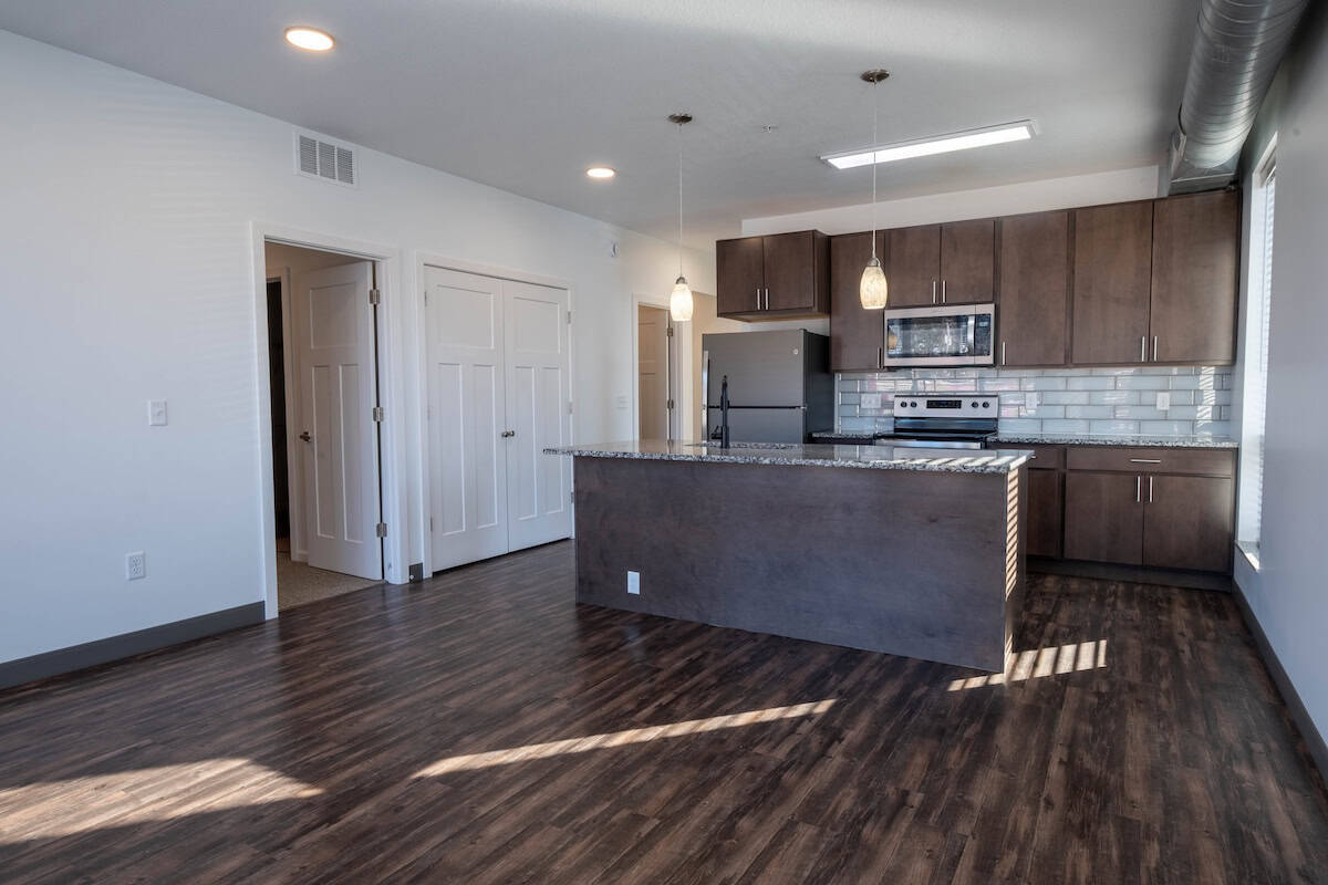 Spacious kitchen area featuring dark wood cabinets, stainless steel appliances, and a sleek island.
