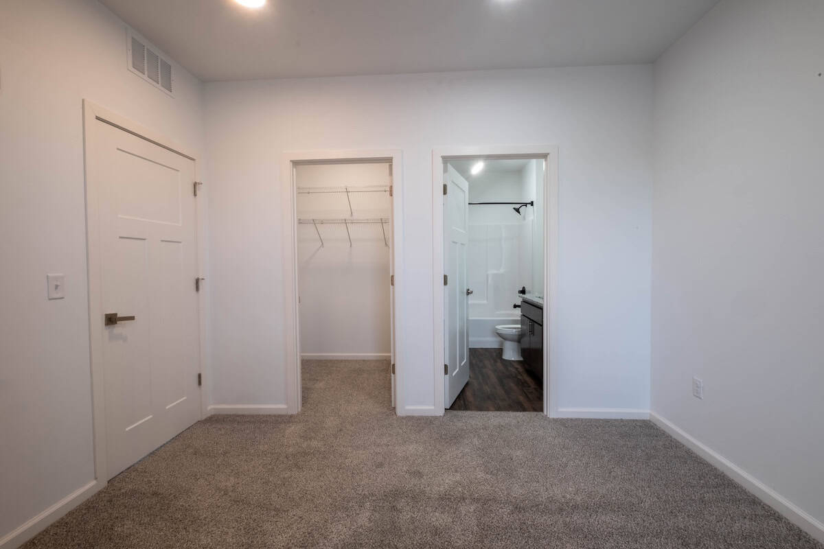Spacious bedroom featuring a walk-in closet and an en-suite bathroom in The Pearl Apartments, Minnea.