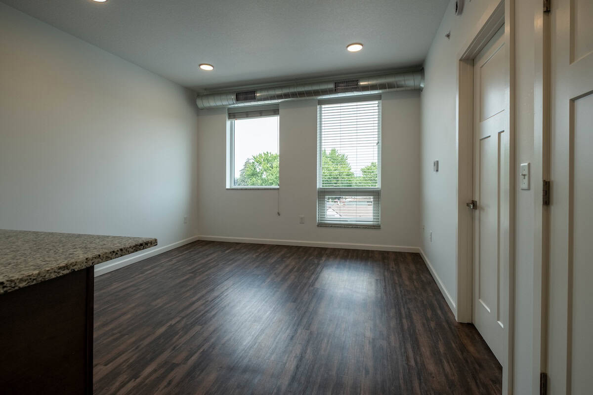 Bright and spacious living room in Minneapolis apartment with large windows and hardwood floors.