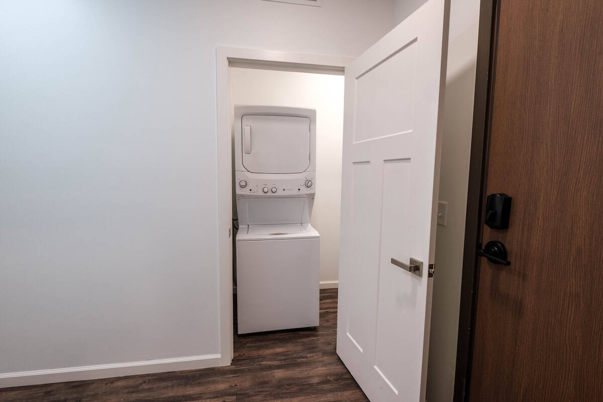 Laundry area with stacked washer and dryer in a modern apartment unit.