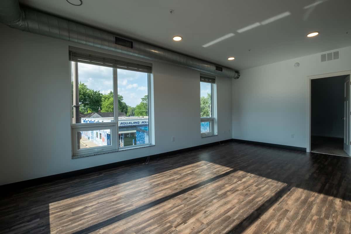 Spacious interior with natural light streaming through big windows, showcasing a contemporary apartm.