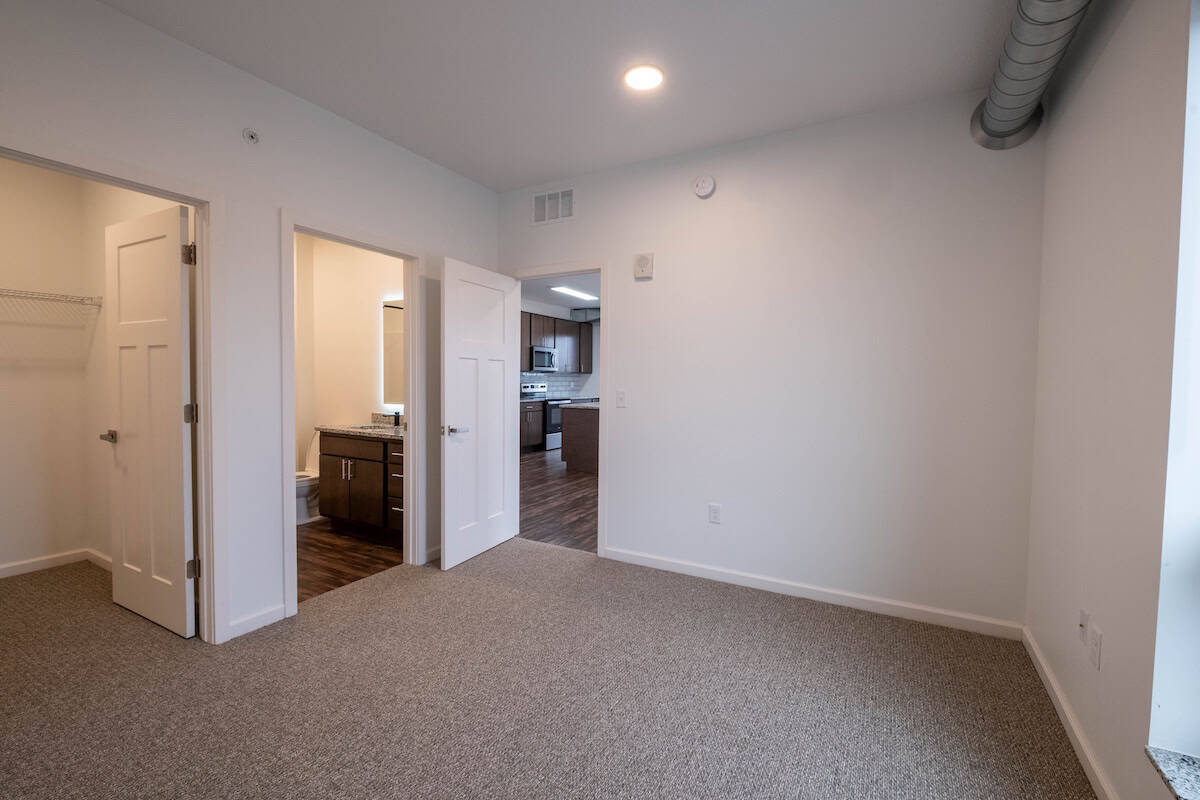 Modern apartment interior with open doorways and neutral decor.