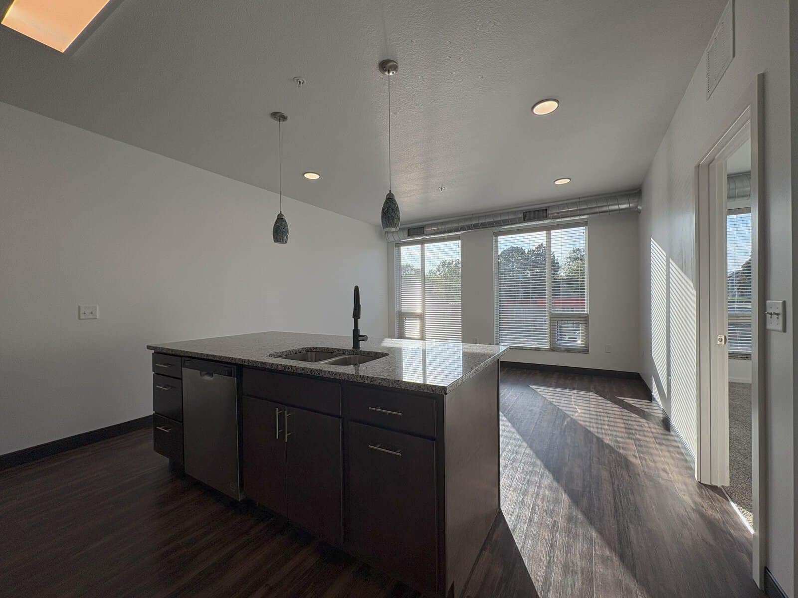 Modern kitchen with large windows and open living space.