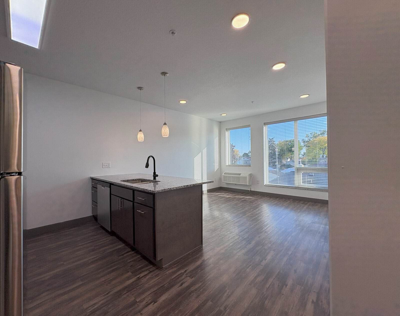 Spacious open-concept kitchen and living room in Minneapolis apartment with large windows and modern.